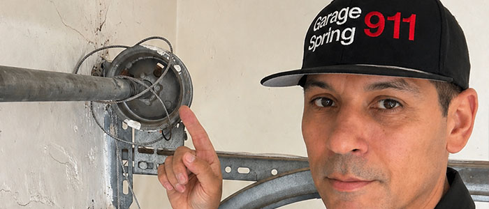 Garage door repair technician replacing a broken cable in San Diego CA.